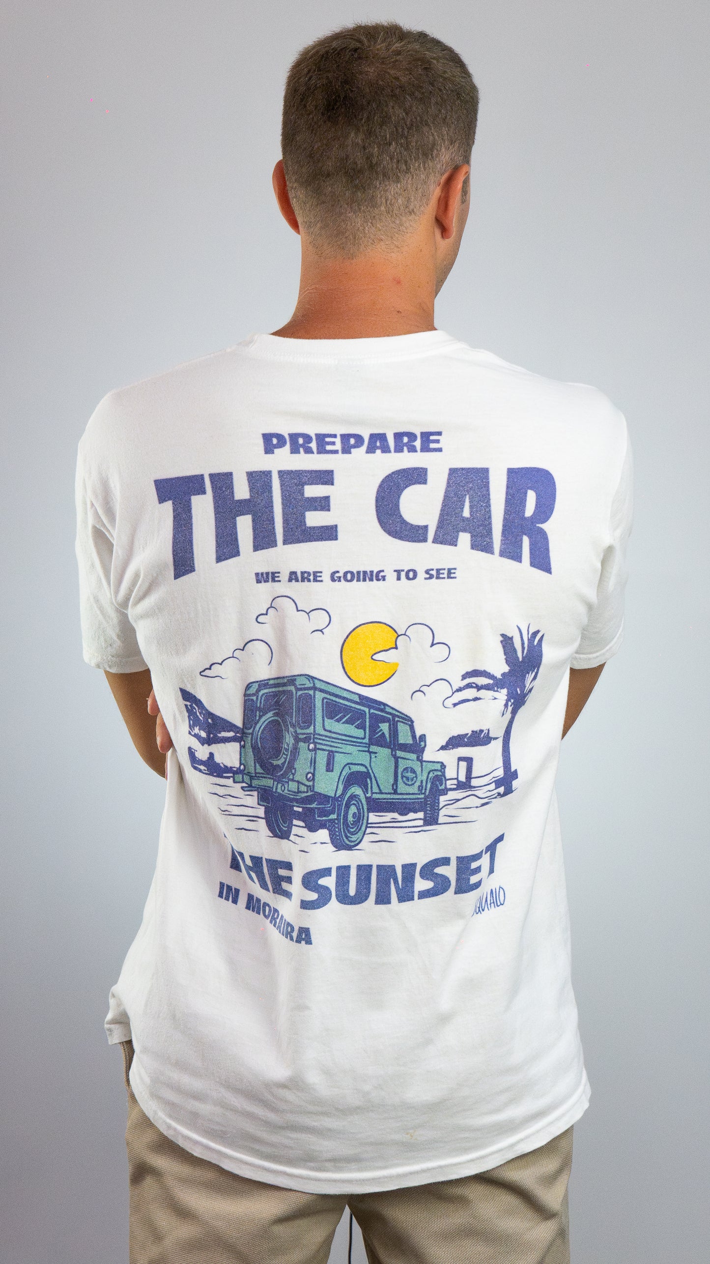 Hombre con camiseta blanca SQUALO, estampado trasero 'Prepare the Car, the Sunset in Moraira' con todoterreno retro